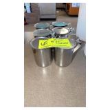 Six stainless steel creamers with lids