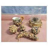 Stone covered oil lamp, pitcher and fruit.