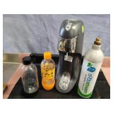 SodaStream machine with COï¿½ and drink  bottles.