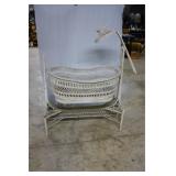 White wicker rocking basinet on stand with mobile