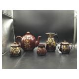GROUP OF BROWN CERAMIC TEAPOTS CREAMERS SUGARS