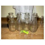 GROUP OF 4 CLEAR GLASS MILK BOTTLES, 10 IN HEIGHT