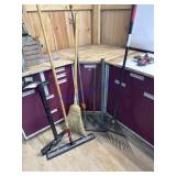 Assorted brooms, rakes, squeegees pipe clamp
