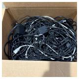 Large box full of miscellaneous power cords
