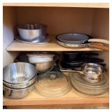 Cupboard full of metal mixing bowls Pyrex serving