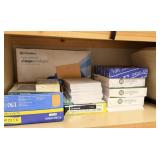 Shelf of printer paper, manila envelopes, paper
