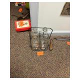 4 vintage glass milk bottles in a metal holder