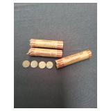 Four rolls of pennies with loose coins