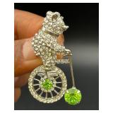 vintage brooch featuring a bear riding a bicycle