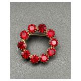vintage brooch features faceted red rhinestones