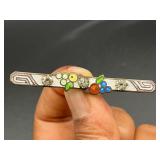 Art Deco enamel bar pin features intricate geometr