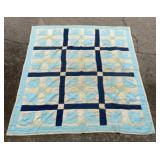 Handmade quilt featuring a block pattern designed