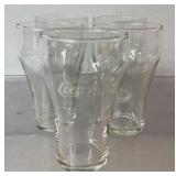 5 Coca Cola glasses, 2 have water residue stains,