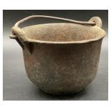 Antique cast iron smelting pot with handle.