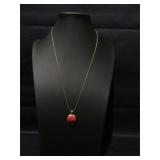 Gold tone chain with red and black pendent