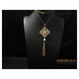 Goldtone filgree pendent with a tassel