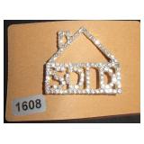 House-Shaped Rhinestone Brooch with 'SOLD' Text