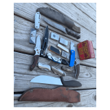 Assorted Collection of Pocket Knives, Utility Blades, and Lighters with Storage Tin