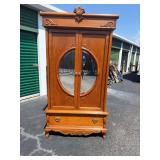 Armoire with circular mirror on front doors