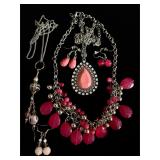 Lots of pink jewelry necklaces, earrings