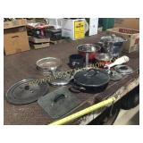A lot of mismatched, pots pans, bowls, lids, and