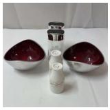 2 salt and pepper shakers and 2 silver/red bowls