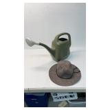 Watering can with gardening hat.
