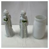 2 lighted figurines and a glass vase.