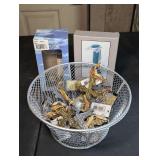 WIRE BASKET FILLED WITH METAL CROSS ORNAMENTS, HIGH-TECH BOOK LIGHT WITH STAND IN ORIGINAL BOX, AND AMERICAN LIGHTHOUSE COLLECTION FIGURINE IN ORIGINAL BOX