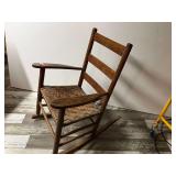 DEN… Antique/vintage wooden rocker with woven seat and ladder back, see pictures for details.