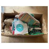 Mystery box of assorted items to include material, woven ladies handbag, seasonal dish towels, knitting needles with storage cases, and much more. See pictures for details.