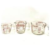 KIT… Glass Pyrex measuring cups, three pieces, graduating sizes, see pictures or details.