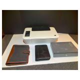 BR3…Shelf lot marked 1564 to include an HP DeskJet 2544, working condition unknown, daily planners, and cash box. See picture for details.