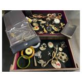 Vintage wooden jewelry box of assorted ladies fashion estate jewelry to include brooches, pocketwatch, cuff bracelet, assorted necklaces, bangle bracelets, and more. See pictures for details.