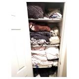 Hallway… Closet lot marked 1541, includes all content of storage closet. Some items include assorted bed coverings, wing chair slip cover, dish towels, bedspreads, quilt, and more. See pictures for 