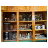 KIT… Upper cabinet lot marked 1078 to include contents from sink edge to refrigerator edge. Some contents include coffee mugs, assorted glassware, stemware, and more. See pictures for details.