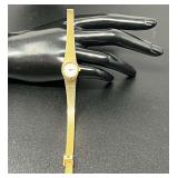 Vintage Oscar de la Renta gold-tone quartz watch with a textured bracelet.