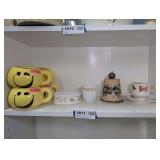SMILEY MUGS, SIGNED POTTERY BELL, AND MORE ON  SHELF MARKED 1611