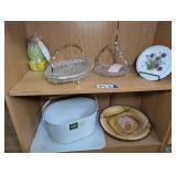 FORMAL GLASS SERVING PIECES, EVERSPRING CLEANING CADDY, CHOPPING BOARD, AND MORE ON TWO BOTTOM SHELVES MARKED 1667