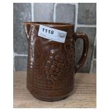ANTIQUE NORTH STAR STONEWARE COMPANY PITCHER WITH A BROWN GLAZE AND A RAISED GRAPE AND TRELLIS DESIGN