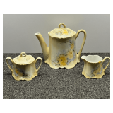 Beautiful porcelain tea set, with sugar, creamer, and teapot, pale yellow with floral motif, the creamer was cracked but re-glued, see pictures for details.