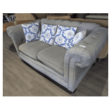 FULLY UPHOLSTERED GRAY LOVESEAT WITH NAIL HEAD TRIM AND ACCENT PILLOWS