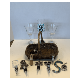 SHELF LOT TO INCLUDE 2 CRYSTAL WINE GLASSES, HAND PAINTED "S" WINE GLASS & BASKET OF ASSORTED WINE STOPPERS