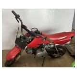 Red Honda XR50R / CRF50F youth dirt bike features bright red plastics and a compact 49cc four-stroke engine. Working condition unknown.