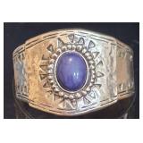 Wide Silver-Toned Cuff Bracelet Features a Central Oval Purple/Blue Stone (possibly lapis). Bracelet Stretches for all Size Wrists