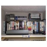 VINTAGE VHS REWIND MACHINE AND VHS MOVIES ON TOP SHELF MARKED 1112 - BR2