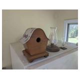 WOODEN BIRDHOUSE WITH GEORGIA PURPLE HEART LICENSE PLATE ROOF, CANDLESTICK WITH GLASS SHADE, AND THERMOMETER ON TOP OF REFRIGERATOR