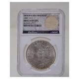 1887 MORGAN SILVER DOLLAR COIN WITH ORIGINAL BAG FRAGMENT, NGC BRILLIANT UNCIRCULATED