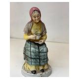 Figurine elderly woman sitting, drinking coffeer