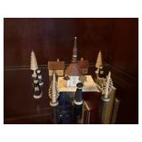 small wood carved village with buildings & people